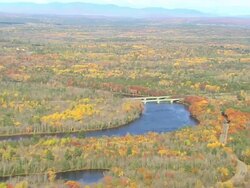 WS AERIAL ZI View of small bridge on river in wooded area with autumn color at Howland / Maine, United States Stock Footage