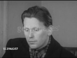 1953: REFUGEES: BERLIN, GERMANY: VS Interviewers speaking w/ various East Berlin refugees at table during interview, refugees talking (SOT, barely audible), paperwork. Instructional Video