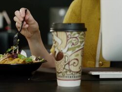 CU Mid section of young woman eating salad while working at office desk / Provo,Utah,USA Stock Footage