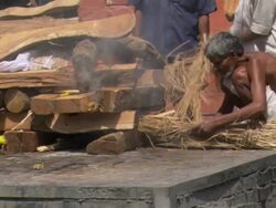 MS Men putting straw into burning funeral pyre / Kathmandu, Central Region, Nepal Stock Footage