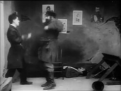 B/W 1917 policeman Charlie Chaplin fighting large man + climbing man to reach manhole above Stock Footage