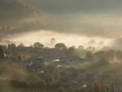 Early morning autumn mist and chimney smoke from the village of Uley, Gloucestershire, UK Stock Footage