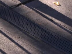 A long grate leads to a sewer drain. Stock Footage