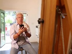 MS PAN Shot of artist talking on phone and taking photos of his painting / Santa Fe, New Mexico, United States  Stock Footage