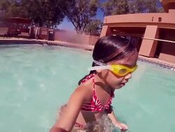 Little Girl Jumps off Dad's Legs in Pool Stock Footage