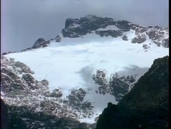WA High angle view of snow covered Rwenzori mountain, clouds shadows moving across snow, Uganda Stock Footage