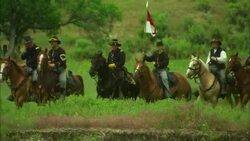 American 7th cavalry on horseback riding through countryside with regiment flag Stock Footage