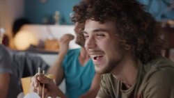 Guys sitting on couch watching funny movie Stock Footage