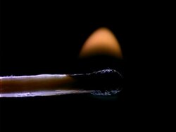 Match lights up, CU flame, black background Stock Footage