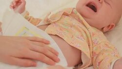 Mother changing diaper to her crying baby Stock Footage