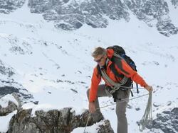 Pan down from father to son scaling cliff, offers assistance Stock Footage
