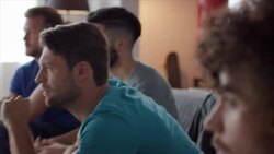 Guys sitting on couch watching horror movie Stock Footage