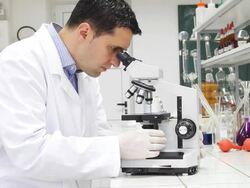 Researcher looking into a microscope in lab. Stock Footage