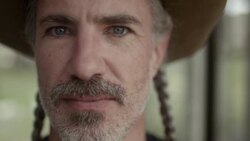Proud Texas man with cowboy hat and braided hair stares into camera Stock Footage