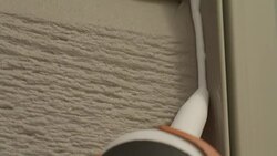 Close up of the tip of a caulking tube filling a space on a home exterior to weatherproof. Stock Footage