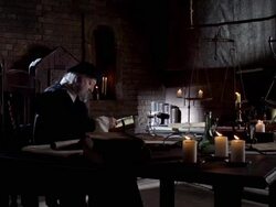 Nostradamus sits at a desk and reads by candlelight. Stock Footage