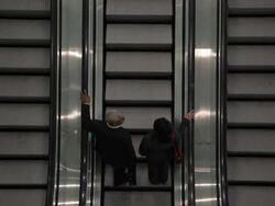 HA Two business associates riding up one of three escalators / Seattle, Washington, United States Stock Footage