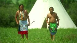 Two Native American Indian young boys throwing spears with Tepee behind Stock Footage