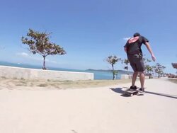 MS POV Two men's skateboarding on side walk near beach area / Uruma, Okinawa, Japan Stock Footage