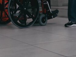 Hospital. Patient sitting in wheel chair and a passer in sneakers Stock Footage