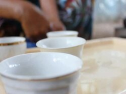 Woman rinsing coffee cups and setting them on a tray Stock Footage