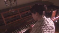 A woman wearing a shawl plays the piano. Stock Footage
