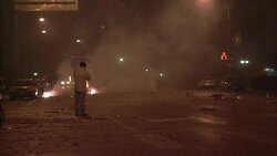 Pedestrians walk past men who shoot fireworks on a street in Beijing. Stock Footage