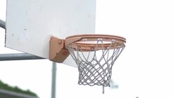 Basketball going into outdoor basketball hoop. Stock Footage