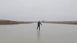 Young man ice skating on frozen pond in winter in rural Montana, USA. Stock Footage