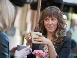 Women have a latte at sidewalk cafe. Stock Footage