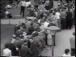 B/W 1961 high angle crowd of East German refugees in line outdoors / beginning of Berlin Wall / West Berlin Stock Footage