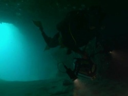 Cave entrance, diver with lights to camera from entrance, Borneo, Malaysia, Southeast Asia Stock Footage