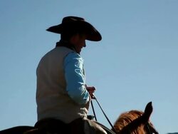 MS Cowboy riding  away on horse along dirt road / Kirkland, Arizon, USA Stock Footage