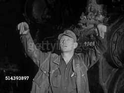 1953: UNION PACIFIC HEAVY CONSTRUCTION AND REPAIR SHOP:  VS Crane moving train engine top over driving wheels in factory, foreman Phil Lang signaling, engine lowering down to wheels in place, other workers in position. Instructional Video