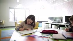 Schoolboy watching schoolgirl color at classroom table Stock Footage