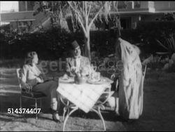 1952: CAIRO, EGYPT: WS Anonymous middle-aged wealthy landowner sitting outside w/ family, Turkish wife & daughter, speaking to brown skin servant, NO SOT, MS Servant, Lighting cigar for landowner. Upper class, wealth, old rules, land reform. Instructional Video