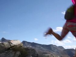Female trail runner bounds along ridge crest, to summit Stock Footage