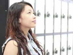 Female standing in locker room contemplating Stock Footage