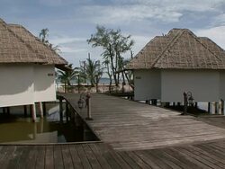 MS boardwalk going by some of tropical resort villas / Sihanoukville, Cambodia Stock Footage