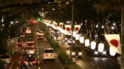 Traffic passes by a median lined with flags. Stock Footage