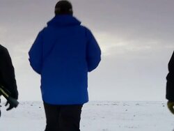 WS Shot of three men in snow suits walking on frozen land with sun and clouds / Arviat, Nunavut, Canada Stock Footage