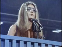 Feminist Gloria Steinem speaks into the microphones at a podium. News Clip
