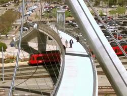 LS ZI pedestrians walking across pedestrian bridge and tram passing underneath / San Diego, California, USA Stock Footage