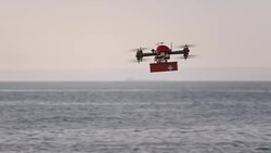 SLO MO UAV transporting first aid kit above the sea Stock Footage