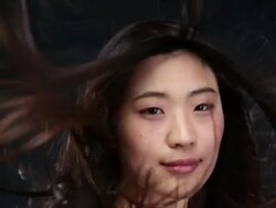 CU SLO MO Asian woman looking towards, smiling and hair moving in wind / London, Greater London, United Kingdom Stock Footage