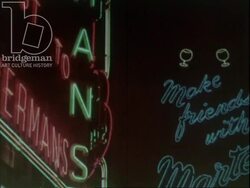 London at night - city lights, roasted chestnut vendor, glamorous couple in restaurant. c.1960 Stock Footage