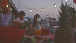 Playing guitar with friend on rooftop party Stock Footage