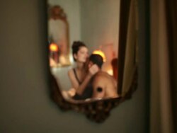 Reflection in mirror of loving young couple on bed  Stock Footage