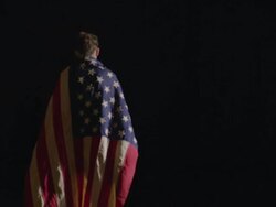 woman walking into the darkness with American flag draped over her Stock Footage