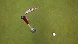 A small american flag blowing in the wind on a putting green. Stock Footage